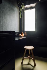 a stool in a room with a window at Equador Studios by Olala Homes in Cascais