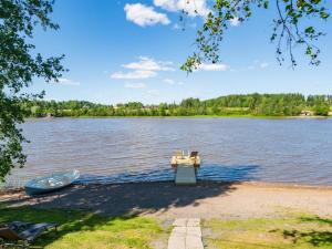 a boat sitting on the shore of a lake at Holiday Home Peukaloinen by Interhome in Hirsjärvi