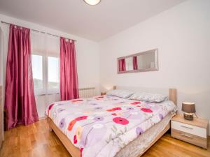 a bedroom with a bed with a floral comforter at Holiday Home Ulika by Interhome in Golaš