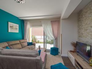 uma sala de estar com um sofá e uma televisão em Holiday Home Valdor by Interhome em Sovlje