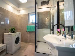 Apartment Rita by Interhome في Dražice: حمام مع غسالة ومغسلة