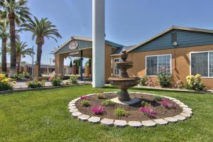 a fountain in the grass in front of a building at Stage Stop Inn Williams in Williams