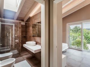 マネルバ・デル・ガルダにあるApartment Rosa by Interhomeのバスルーム(洗面台、トイレ付)、窓が備わります。