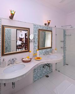a bathroom with two sinks and a mirror at Amet Haveli in Udaipur
