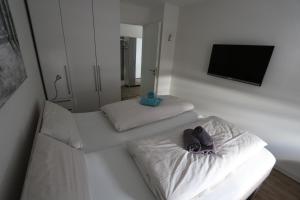 ハイリゲンハーフェンにあるStrandquartier 10 inkl Wäsche Setのベッド2台と壁掛けテレビが備わる客室です。
