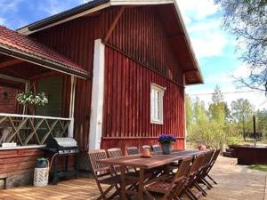 uma mesa de madeira e cadeiras fora de uma casa em Holiday Home Virtaan väentupa by Interhome em Nuoramoinen