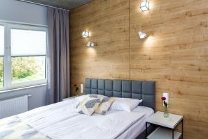 sypialnia z dużym łóżkiem i drewnianą ścianą w obiekcie Hotel 107 w mieście Rumia