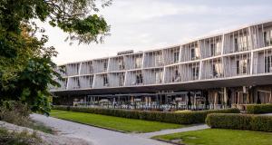 Außenansicht eines Gebäudes mit Tischen und Stühlen in der Unterkunft Hedon Spa & Hotel in Pärnu
