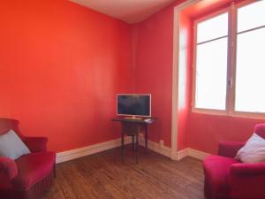 ディナールにあるApartment Les Terrassesの赤い部屋(椅子2脚、テーブル上のテレビ付)
