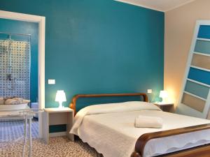 sypialnia z łóżkiem i niebieską ścianą w obiekcie Holiday Home Fior di Sole by Interhome w Manerba del Garda