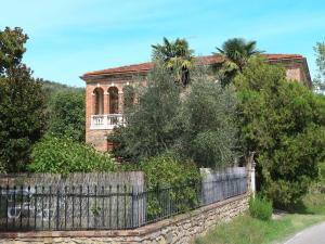 an old brick house with a fence and trees at Holiday Home Podere Casina by Interhome in Sinalunga