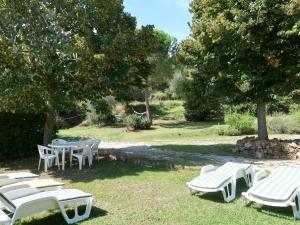 a group of white chairs and tables in a yard at Holiday Home Podere Casina by Interhome in Sinalunga