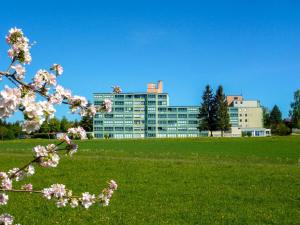 a building with a flowering tree in front of a field at Apartment B 77 by Interhome in Dittishausen