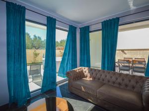 ein Wohnzimmer mit blauen Vorhängen und einem Sofa in der Unterkunft Villa Prova 1 by Interhome in Jezera