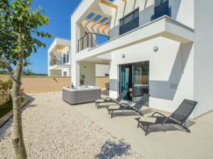 Blick auf ein Haus mit Stühlen und einem Tisch in der Unterkunft Villa Prova 1 by Interhome in Jezera