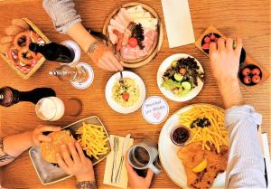 un grupo de personas sentadas alrededor de una mesa comiendo comida en Zur Mühle, en Bad Birnbach