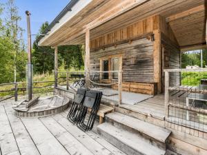 a wooden house with a porch and stairs on it at Holiday Home Koivu by Interhome in Sonkajärvi
