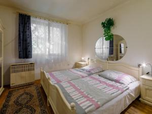 1 dormitorio con cama, espejo y ventana en Holiday Home Kiwi by Interhome, en Balatonfenyves