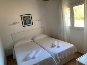 a bedroom with two beds with slippers on them at Apartamentos Vista Vedrá in La Savina