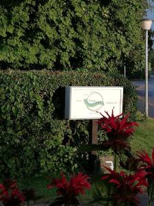 a sign in front of a hedge with red flowers at FW Achterdeck, 1 Obergeschoss, Petershof-Lehbek in Gelting