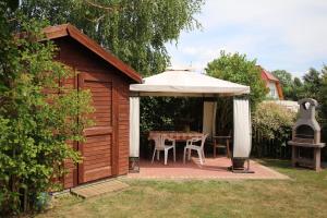 a gazebo with a table and a white umbrella at Apartment 4 in Rewal