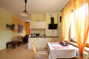 a kitchen and a dining room with a table and chairs at Apartment 4 in Rewal