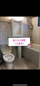 a bathroom with a toilet and a sink and a sign at Meizhou Hot Spring Hotel溫泉商旅 in Jiaoxi