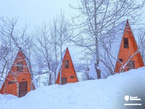 un grupo de casas triangulares en la nieve en Paradiso Mestia, en Mestia