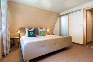 ein Schlafzimmer mit einem großen Bett mit blauen und grünen Kissen in der Unterkunft Haus am Berg - Pension direkt am Skihang in Kurort Oberwiesenthal