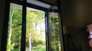een raam in een kamer met uitzicht op een bos bij Apartman Srebrena lisica - Babin do Bjelašnica Free Garage - Kanton Sarajevo in Bjelašnica