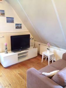 una sala de estar con TV de pantalla plana en un armario blanco en De Slotruine, en Egmond aan den Hoef 13 fotos más