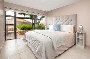 a bedroom with a large bed and a large window at The Guinea Fowl in Reebok