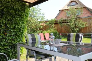 a glass table with chairs around it in a garden at Haus Seeheim in Böhl