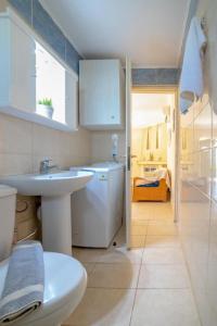 La salle de bains est pourvue d'un lavabo et de toilettes. dans l'établissement Emmanuela House with garden & sea view - Triopetra, à Triopetra