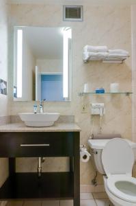 a bathroom with a sink and a toilet and a mirror at Red Lion Hotel Monterey in Monterey +19 photos