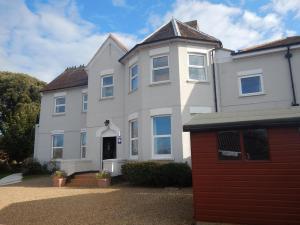 a large white house with a red garage at YHA Isle of Wight Totland - Partner in Totland