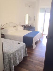 a hotel room with two beds and a table at HR Senigallia, già Hotel Ritz in Senigallia