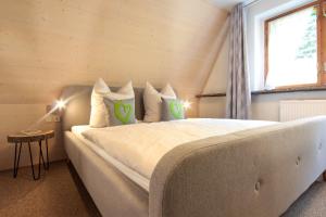 a bedroom with a large bed with green pillows at Haus am Berg - Pension direkt am Skihang in Kurort Oberwiesenthal