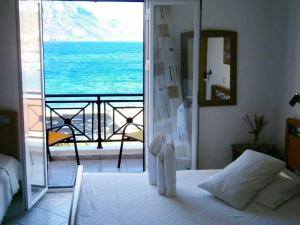 a bedroom with a bed and a view of the ocean at Costareli in Fourni Ikarias
