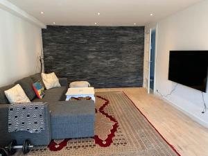a living room with a couch and a flat screen tv at Cozy place close to beautiful nature in Ballerup