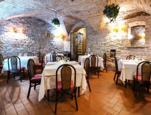 a dining room with tables and chairs and a stone wall at B&B Locanda San Michele in Corciano