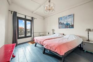 
a bedroom with a bed, desk and a painting on the wall at Turfhuys aan het Spaarne in Haarlem
