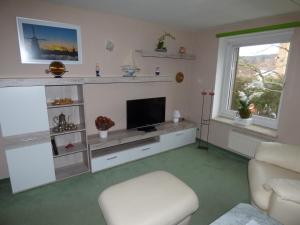 a living room with a television and a chair at Werner's Gästewohnung in Kraftsdorf