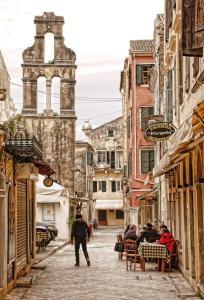 a man walking down a street in a city at Marilù- The downtown suite in Corfu Town