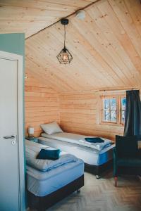 una camera con due letti in una cabina di legno di Rauðuskriður farm a Hólmabæir