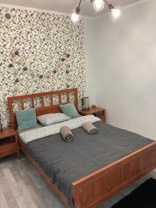 - une chambre avec un grand lit en bois et un mur dans l'établissement Apartament Swobodna No.2, à Sosnowiec