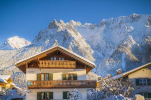 a building with a balcony in front of a mountain at Landhaus Braun in Mittenwald