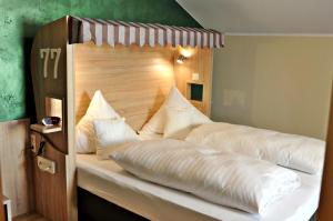 a large bed with white pillows on top of it at Hotel Restaurant Bürgerklause Tapken in Garrel +75 photos