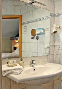 a bathroom with a sink and a mirror at Hotel Restaurant Bürgerklause Tapken in Garrel