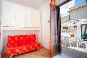 a red couch in a living room with a balcony at Casa Viga in Tre Fontane